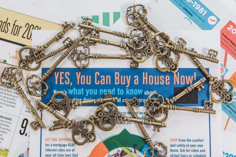 Vintage keys scattered over real estate documents, symbolizing property ownership and investment.