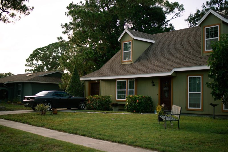 Beautiful suburban home with a manicured lawn and a parked car, emphasizing residential comfort.